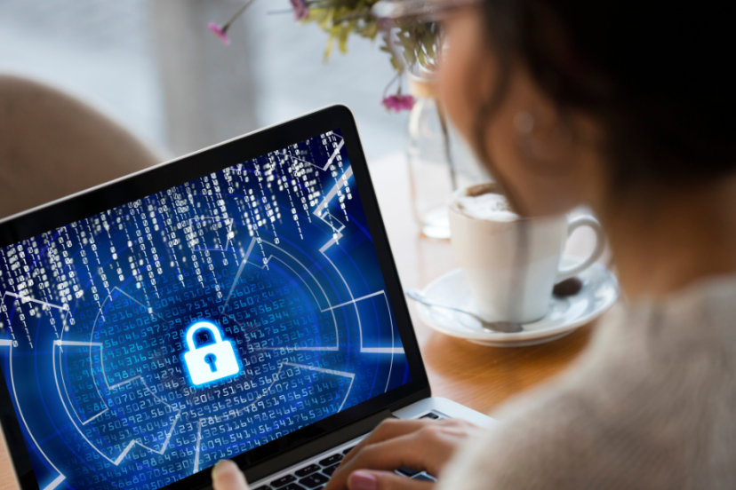 Cybersecurity - Image of young woman sitting at her work from home desk working on her laptop cybersecurity.